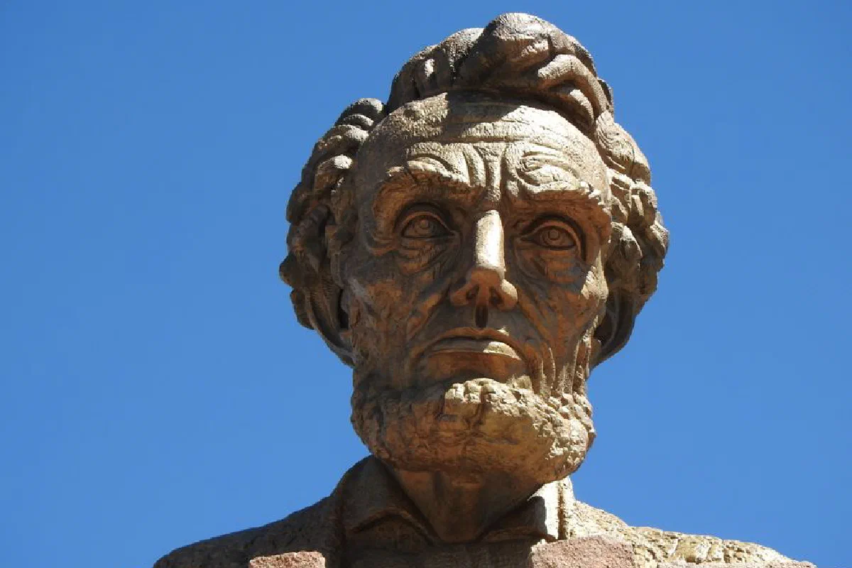 Close-up of a stone sculpture depicting Abraham Lincoln against a clear blue sky.