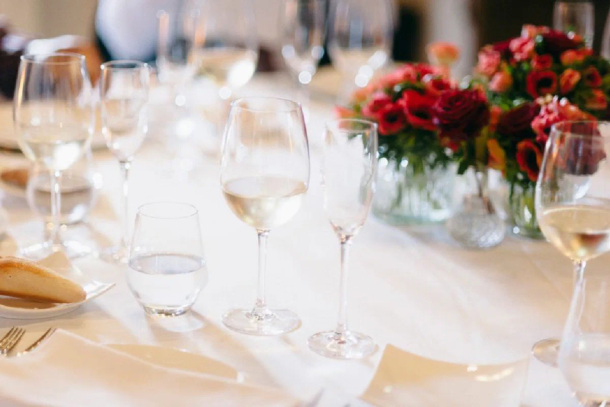 Sophisticated table setup featuring wine glasses and lush floral centerpiece.