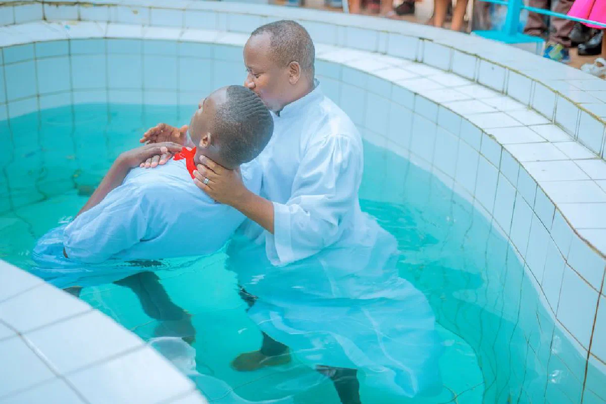 A serene baptism conducted in a swimming pool with two adults in white garments.