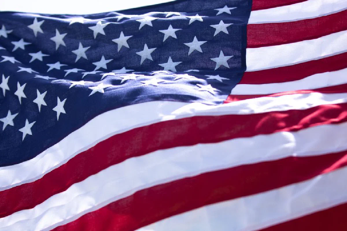 A detailed close-up of the American flag's stars and stripes fluttering against the sky.