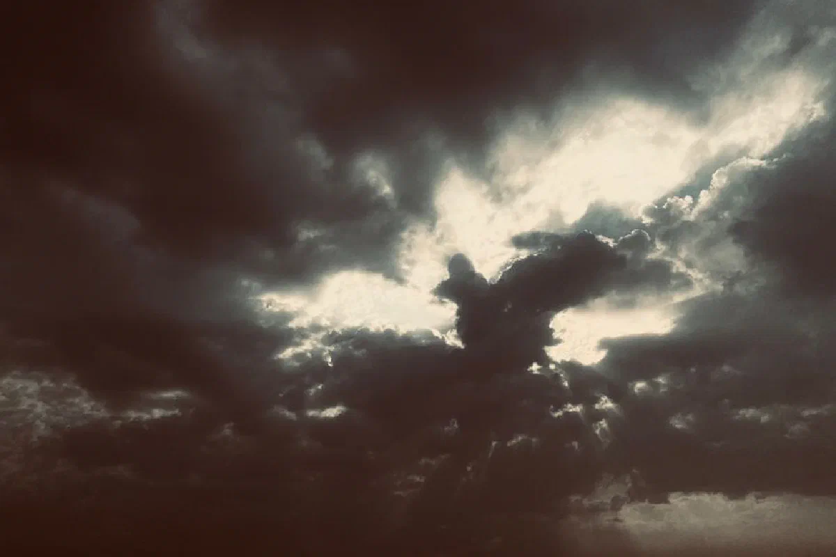 A dramatic view of dark clouds with sunlight breaking through, captured in New Delhi, India.