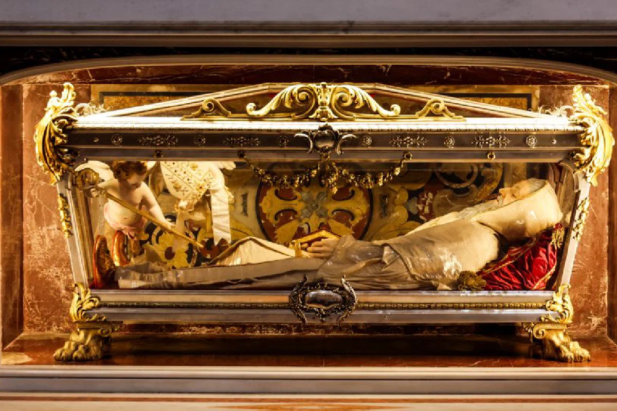 Ornate tomb of a bishop in a cathedral featuring detailed artwork and sculptures.
