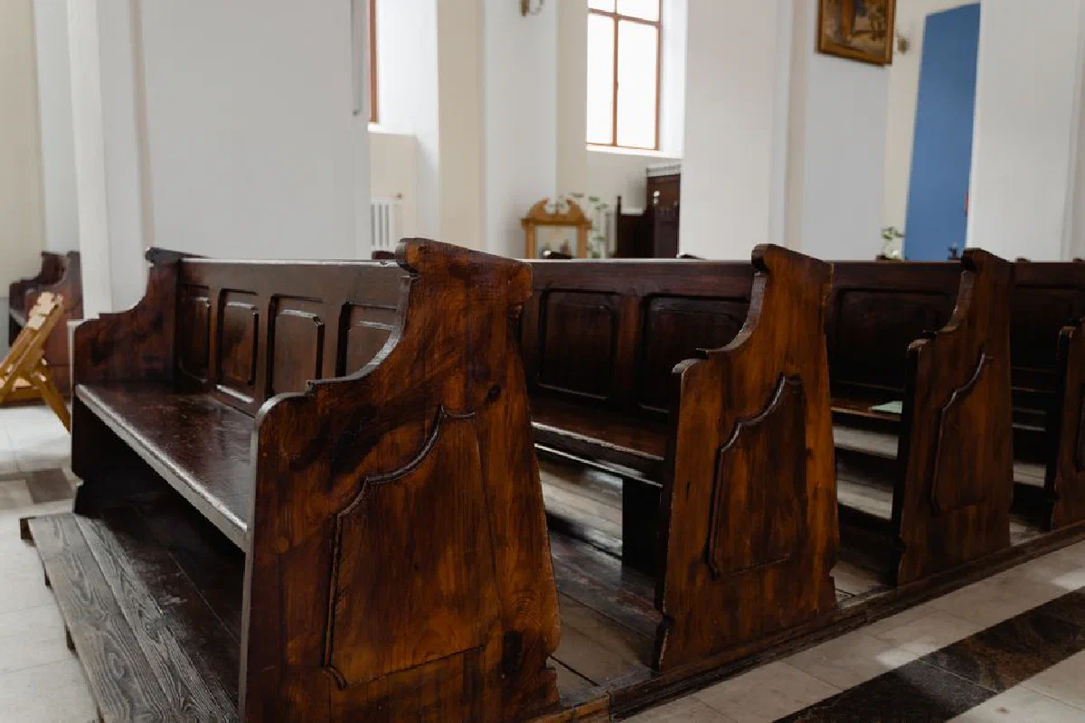 Quiet church interior featuring classic wooden pews, inviting reflection.