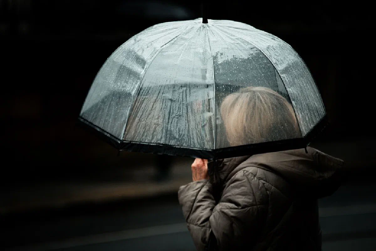 Moody street photography capturing a silhouette with a transparent umbrella in rainy Dublin.