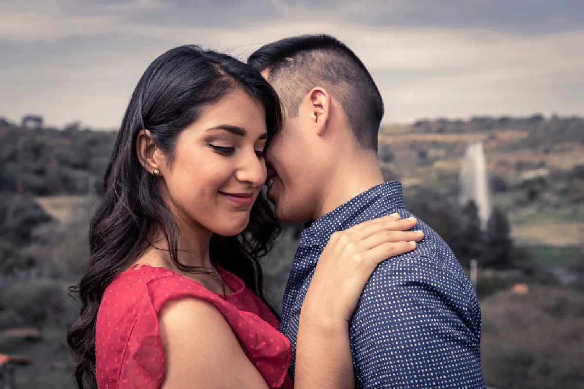 A loving couple embraces outdoors, capturing a moment of romance and affection.