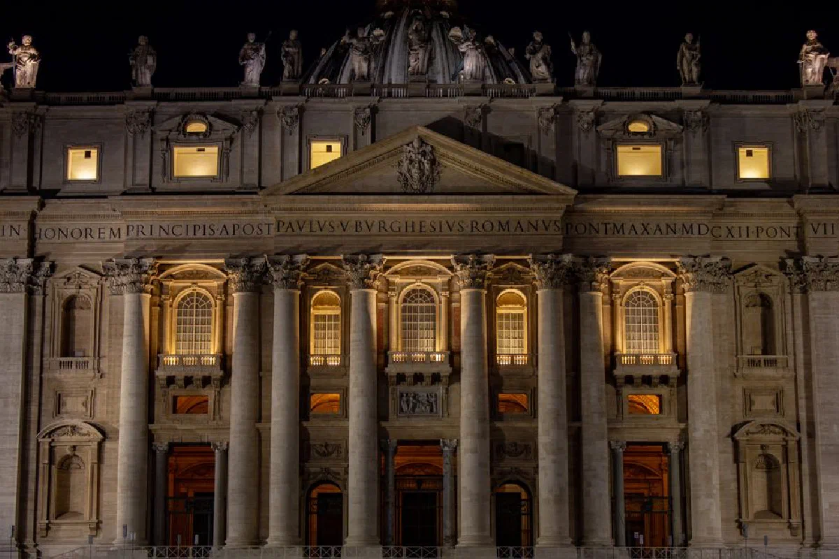 Illuminated St. Peter's Basilica at night, showcasing exquisite architectural details in Vatican City.
