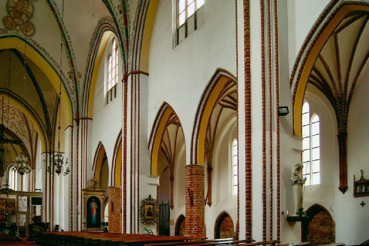 Explore the beautiful gothic arches and stained glass in Kamień Pomorski Cathedral's interior.