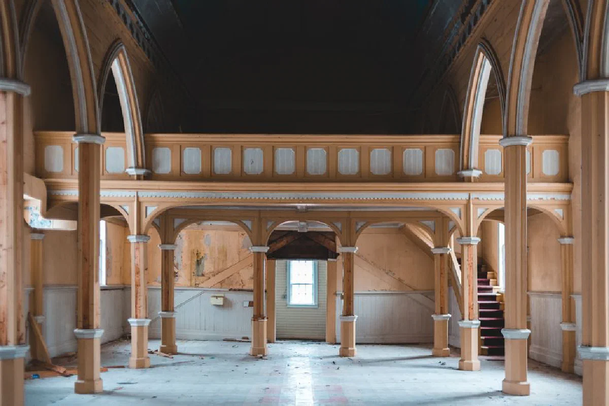 Explore the eerie beauty of an abandoned church with grand wooden arches and vintage architecture.