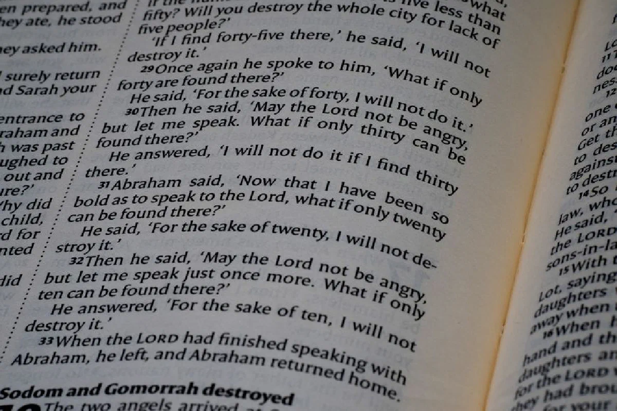 Detailed close-up of an open Bible showing the Book of Genesis text for study.