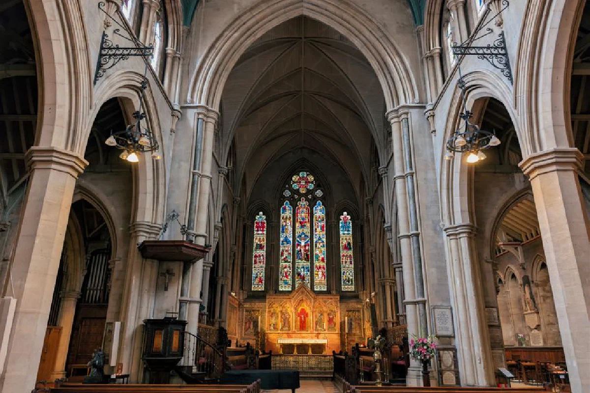 Beautiful view of All Saints Church's interior with stained glass windows and arches in London.