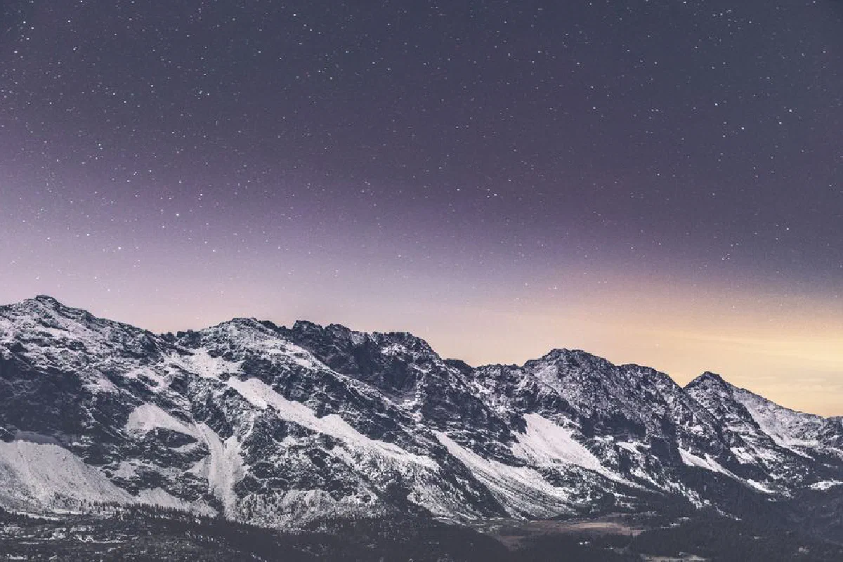 Stunning night sky over snow-capped mountains in Lombardy, Italy. Perfect for nature and travel enthusiasts.