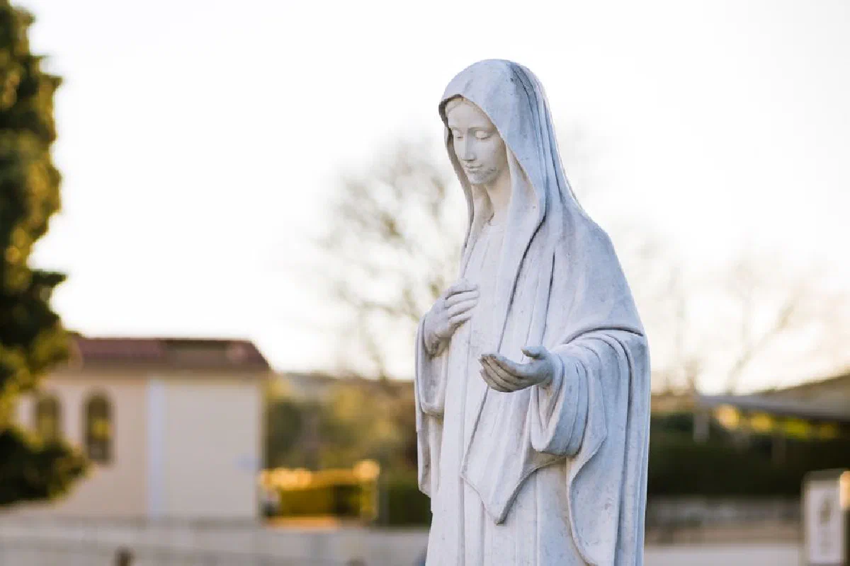 Beautiful statue of the Virgin Mary in Medjugorje, Bosnia captured during a serene sunset.