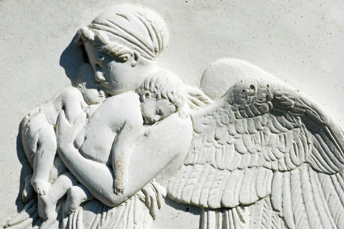 Detailed stone relief depicting an angel cradling two children, showcasing gentle protection.