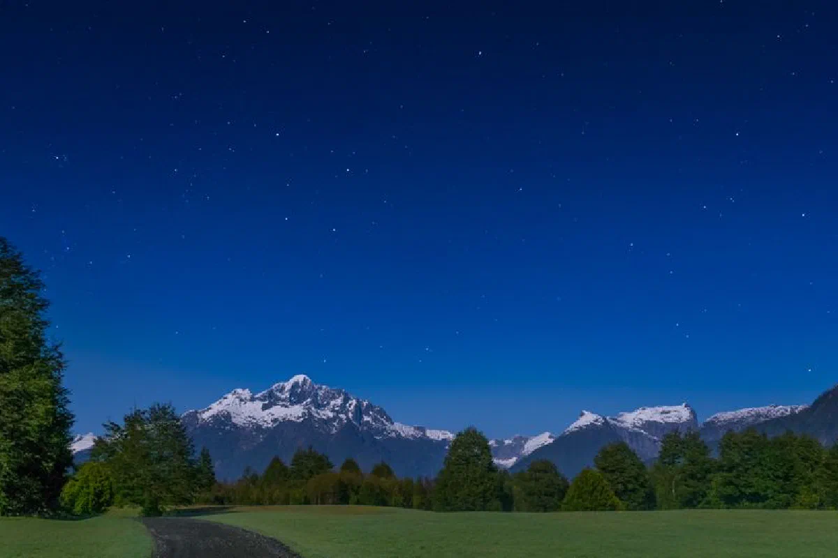 Capture the serenity of snow-capped Andes under a starry night sky in Patagonia.