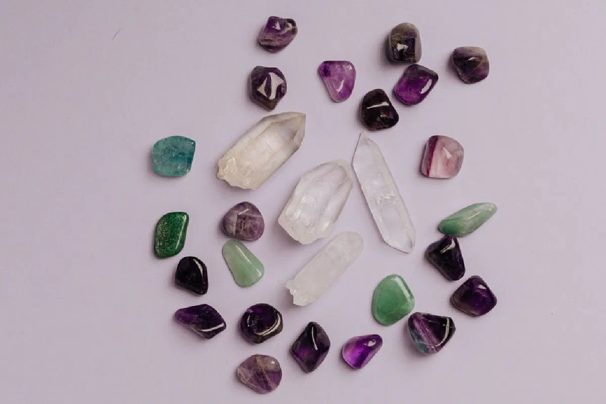 A collection of assorted gemstones including amethyst, jade, and quartz arranged in a flat lay.
