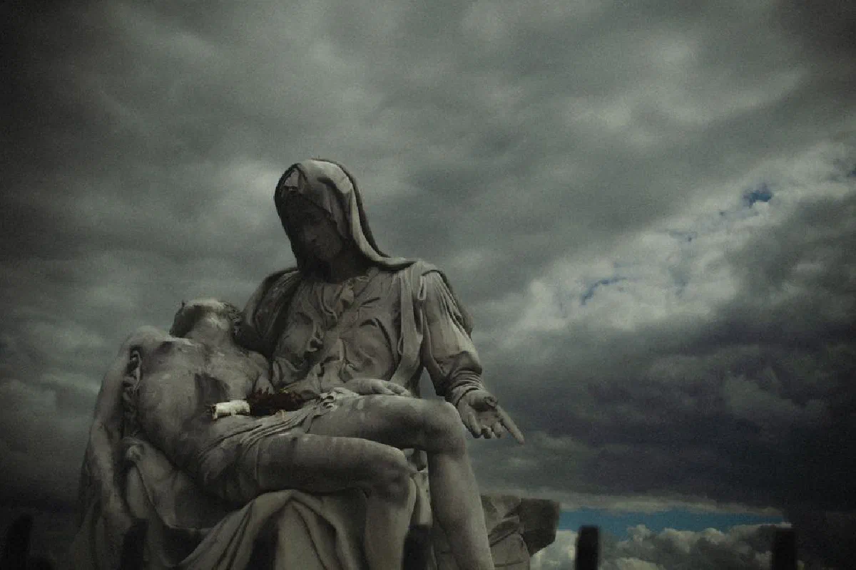 A dramatic statue under stormy skies conveying emotion and artistry.