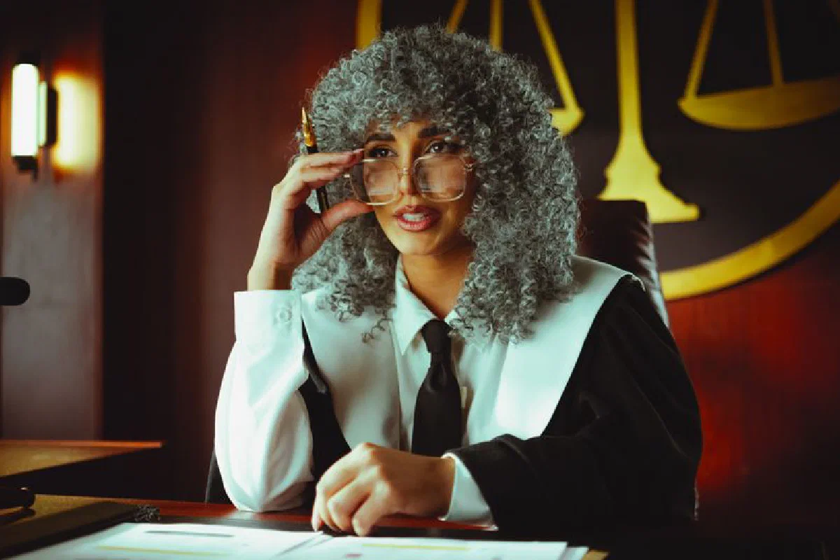An elegant judge in robes sits at a desk in a courtroom, poised and authoritative.