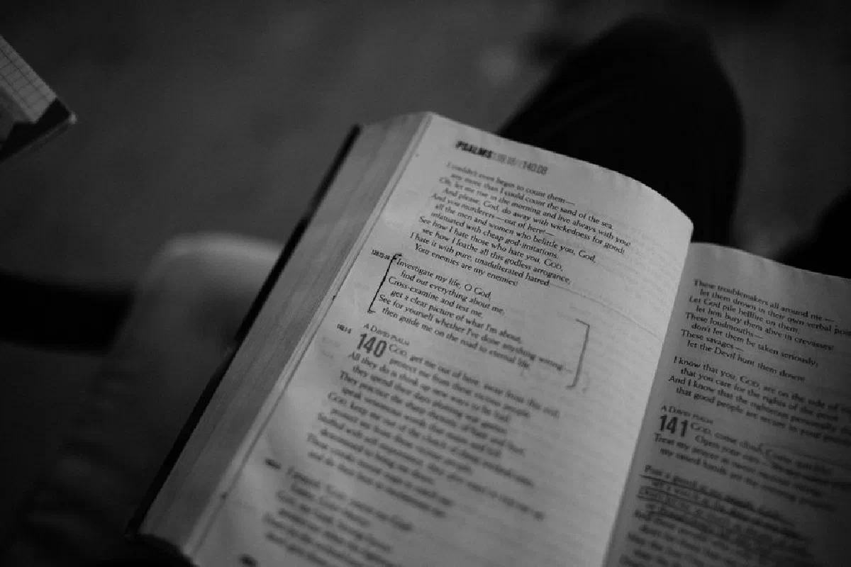 Black and white from above holy book with psalms placed in brackets by reader