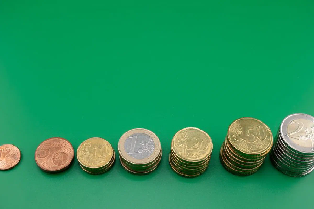 Various euro coins stacked incrementally on a vibrant green background.