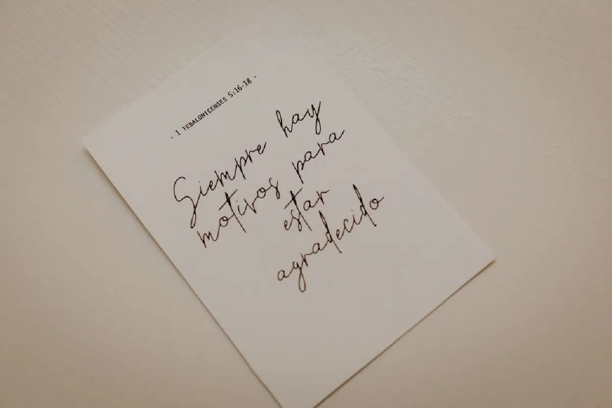 Minimalist photo of an inspirational calligraphy note on white paper.