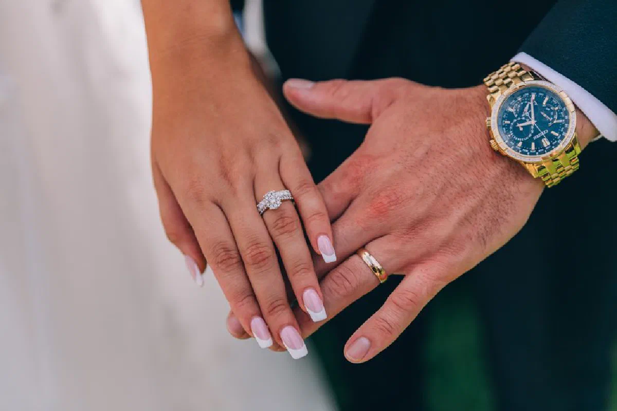 Close-up of a couple's hands showing wedding rings and a luxury watch in Parramatta.