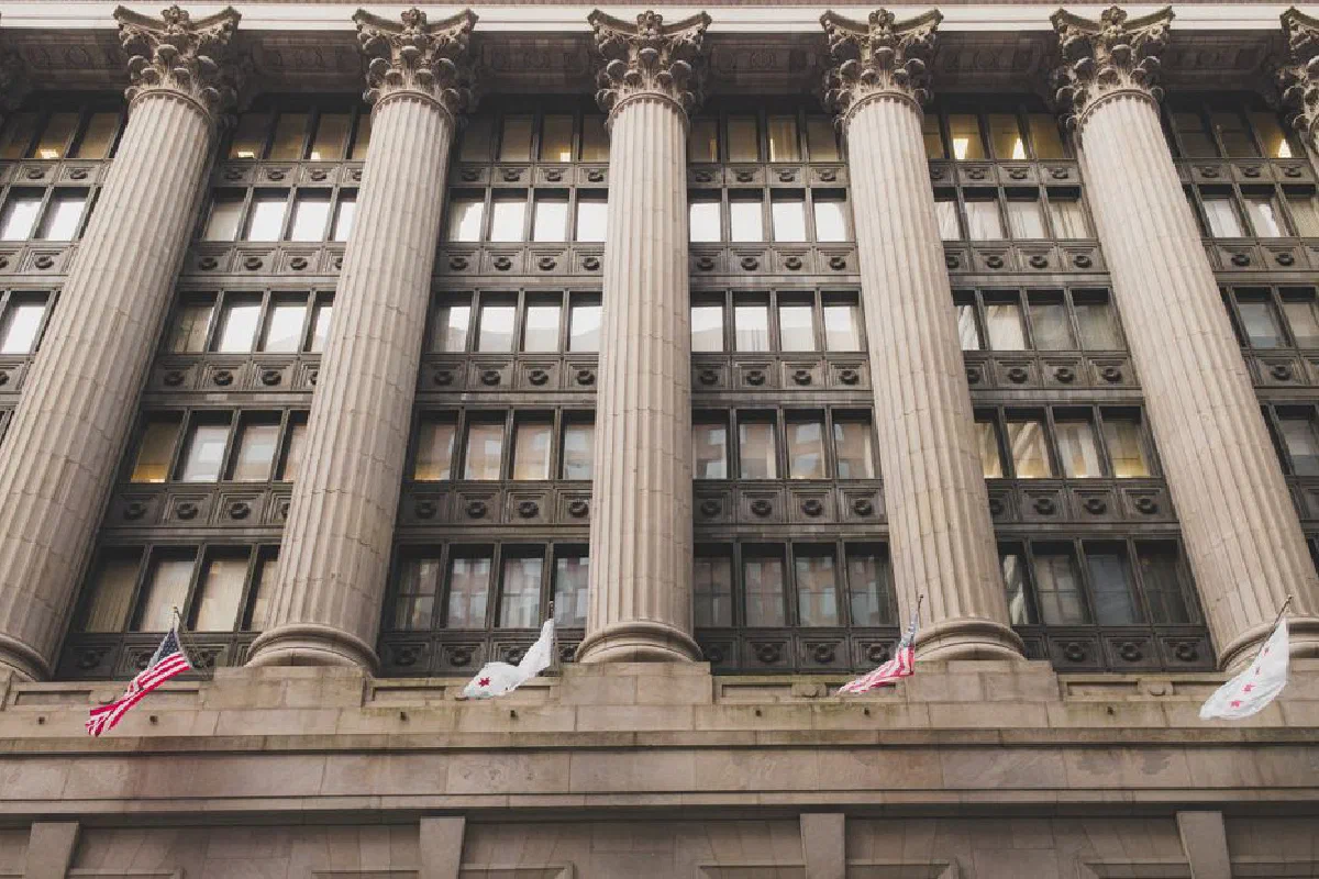Elegant neoclassical facade with columns and flags in downtown Chicago.