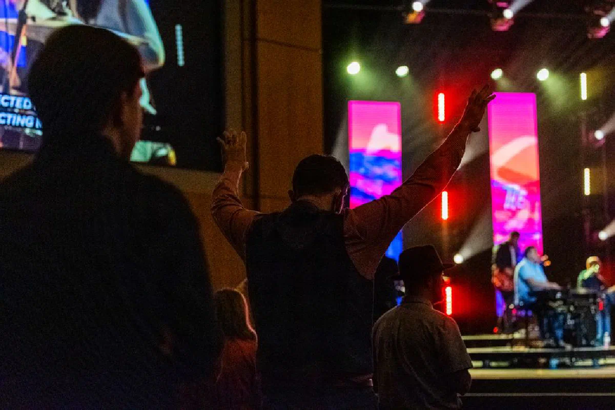 Dynamic live performance captured, showcasing audience engagement with vibrant stage lighting and musicians.