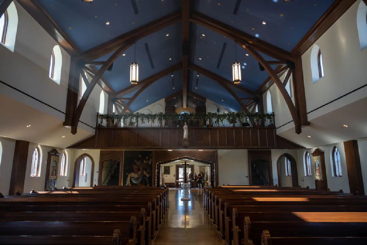 Spacious church interior with wooden beams and stained glass in Norman, Oklahoma.