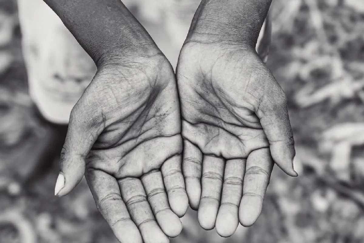 A black and white photo capturing open hands, symbolizing giving or receiving.