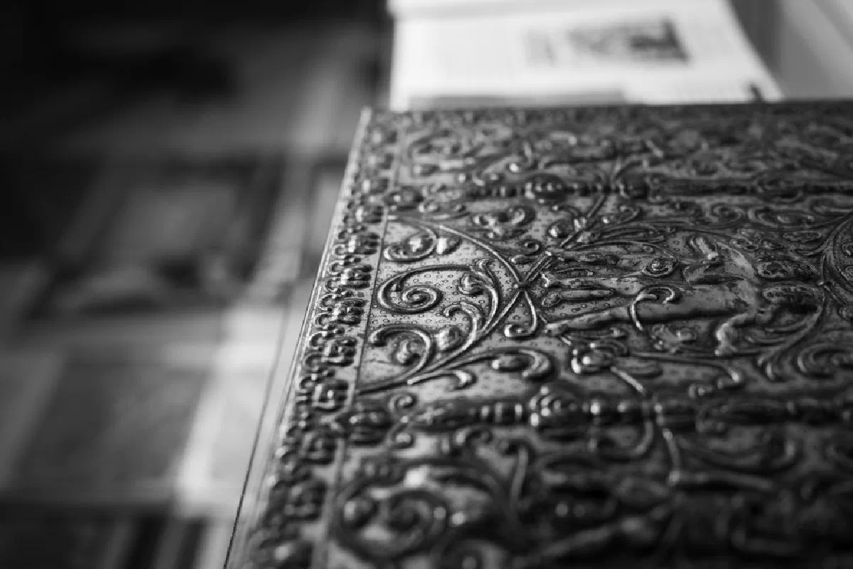 Detailed macro shot of intricate black and white metalwork with artistic patterns.