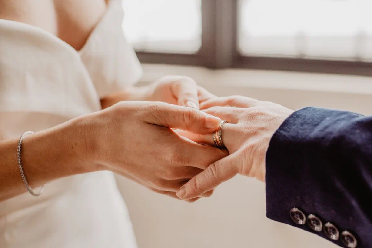 Close-up of couple exchanging rings during a wedding ceremony.