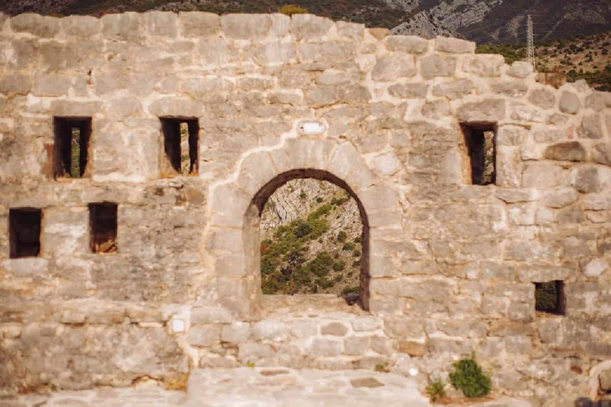 Explore ancient stone fortress ruins featuring a scenic archway overlooking the landscape.
