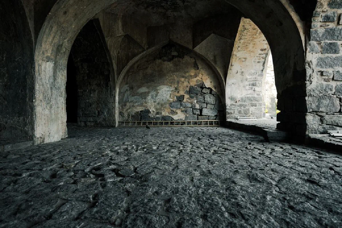 A stunning view of ancient stone arches inside a historic fort in Hyderabad, India.