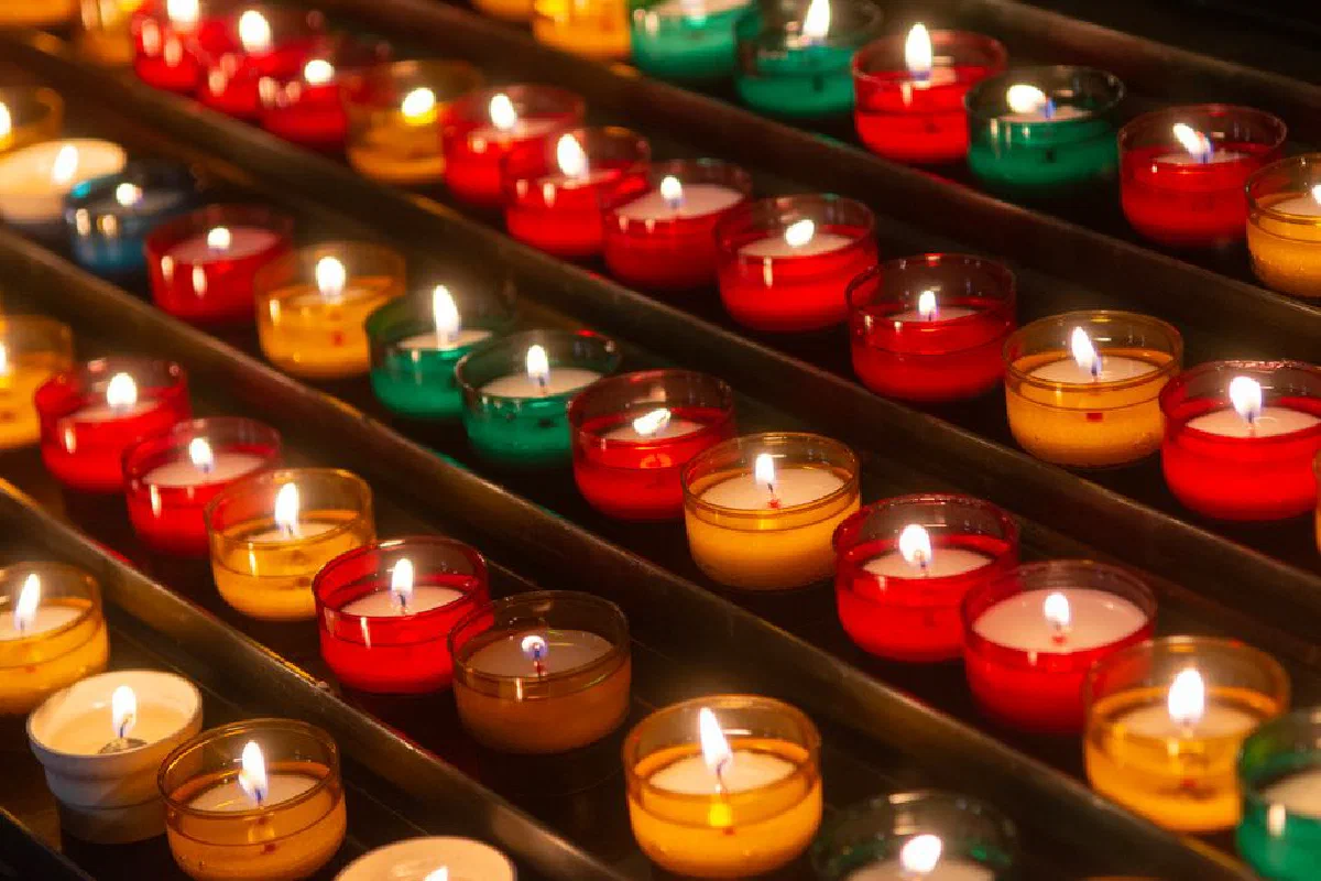 Colorful candles lit in rows creating a warm and serene ambiance.