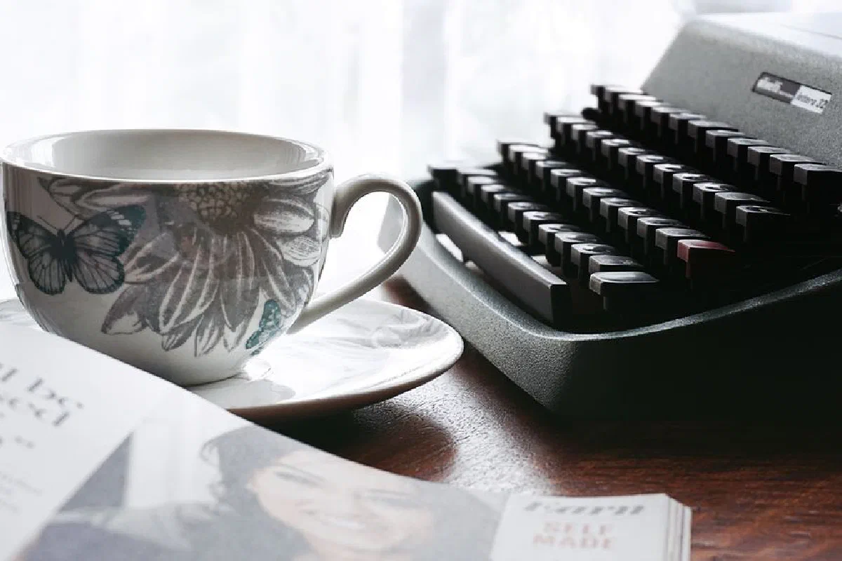 A nostalgic desk scene with a typewriter and floral teacup, evoking retro vibes.