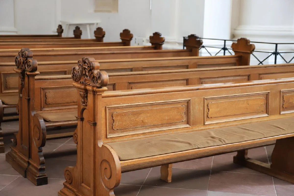 Detailed view of ornate wooden benches inside a church in Fulda, Germany, showcasing craftsmanship.