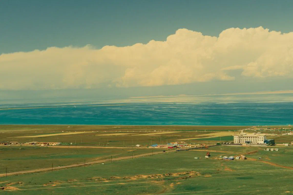 A scenic aerial view of a rural landscape with a village by the coast.