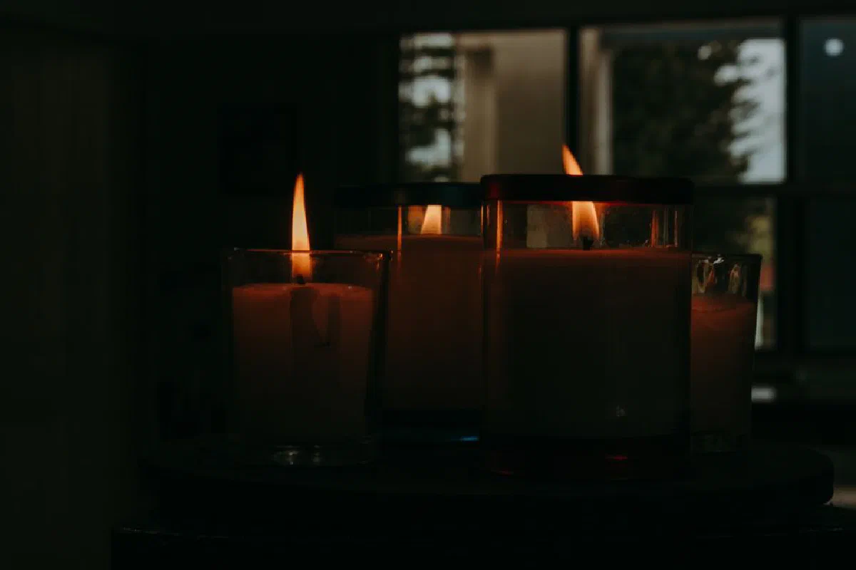 Peaceful arrangement of lit candles casting a warm glow in a dim room, perfect for meditation or relaxation imagery.