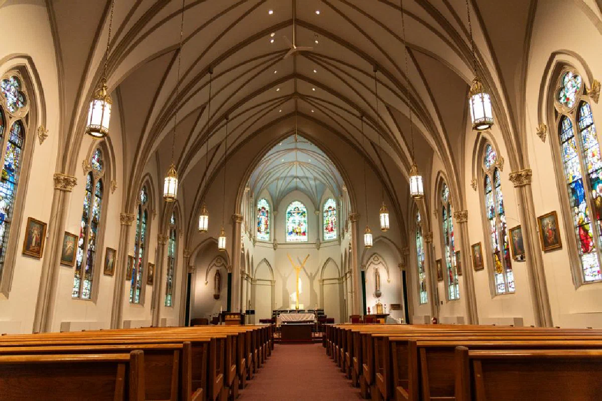 Stunning view of a historic church interior featuring beautiful stained glass windows and vaulted ceilings.