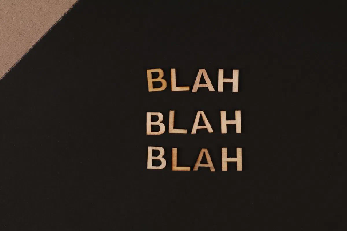Close-up of wooden letters spelling 'blah', arranged on a black background, offering a conceptual design with copy space.