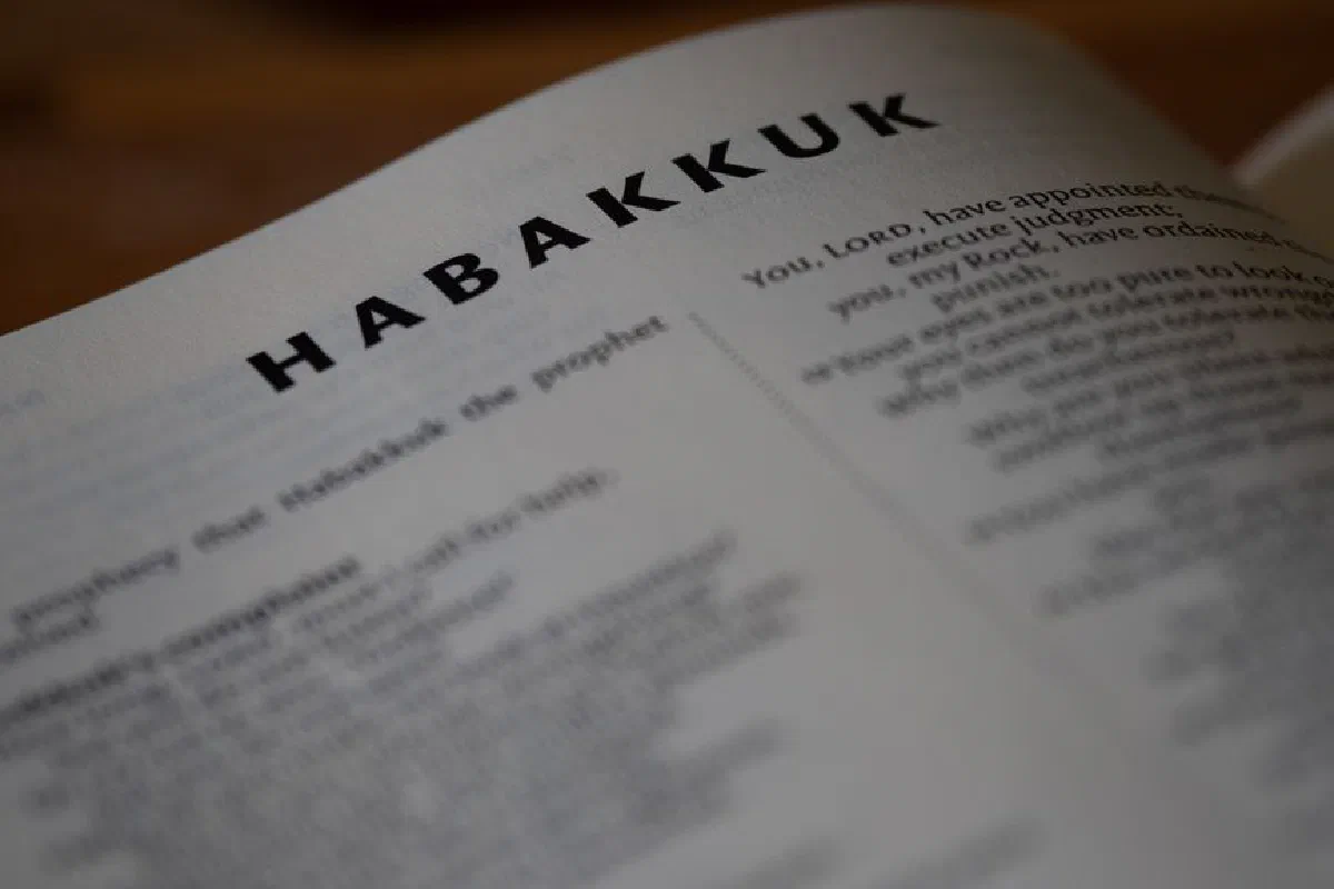 Close-up view of an open Bible showing the book of Habakkuk with blurred background.