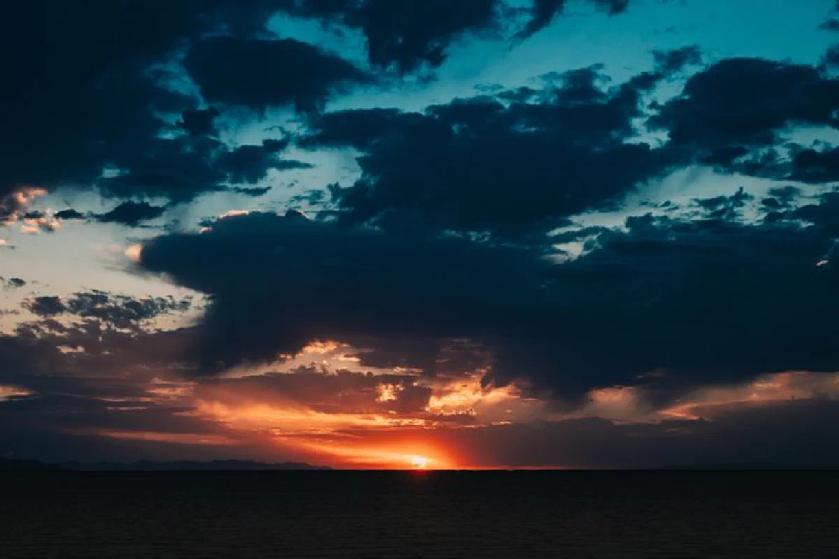 Stunning sunset over the ocean with dramatic clouds and vibrant colors.