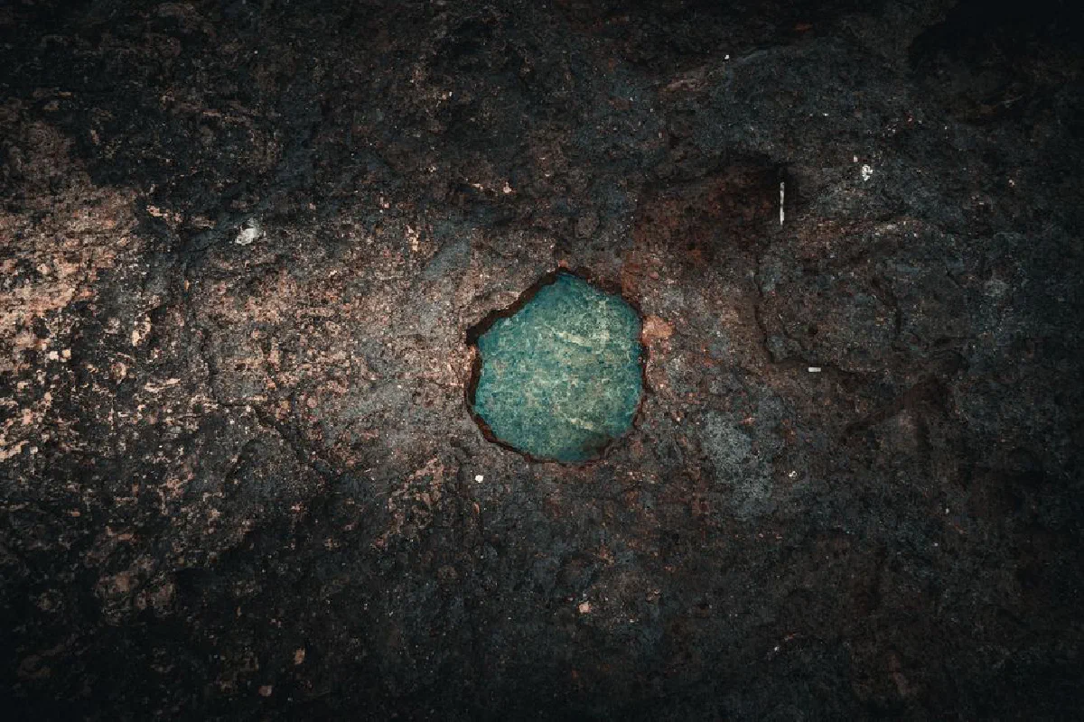 A deep recess in a weathered rock displaying rich textures and colors.