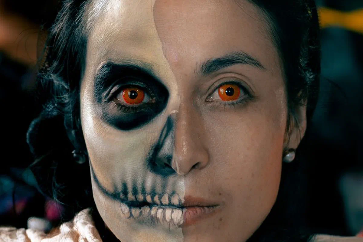 Portrait of a woman with Day of the Dead face paint, showcasing vibrant artistic detail and tradition.