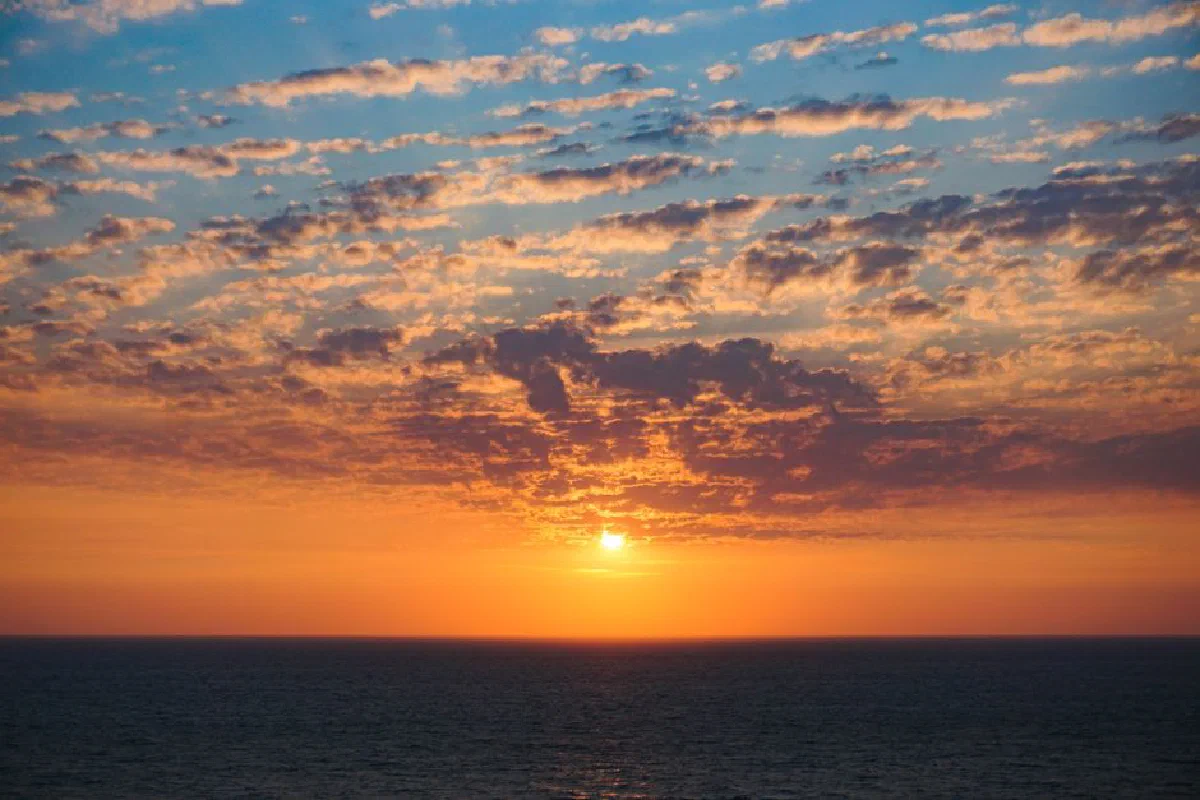 Capture of a breathtaking ocean sunset with vibrant colors and dramatic clouds.