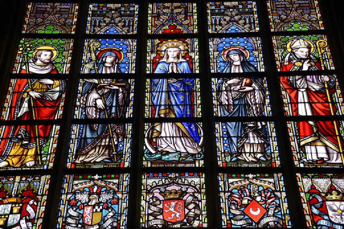 Colorful stained glass window depicting religious figures in a cathedral.