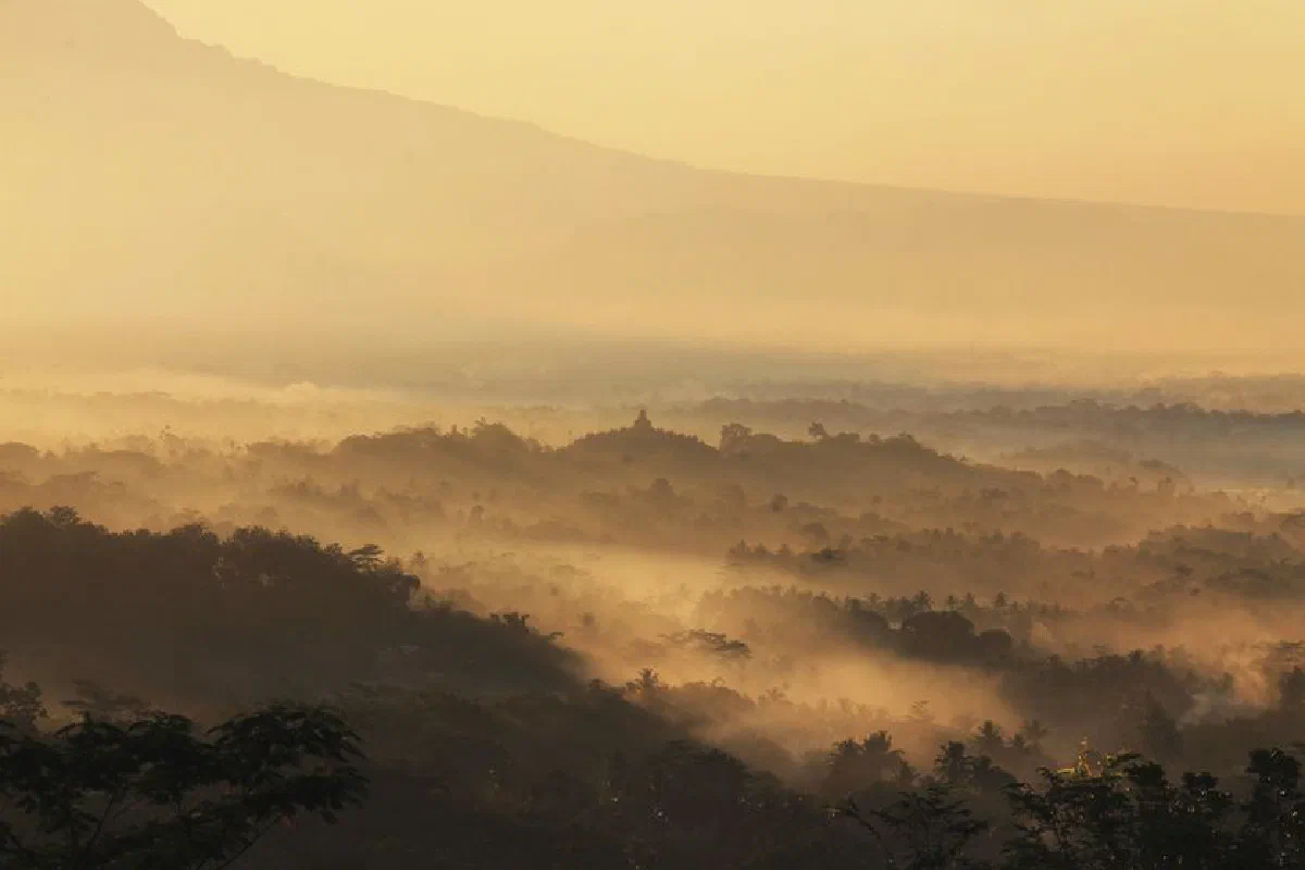 A breathtaking sunrise over misty Indonesian mountains, showcasing nature's beauty and tranquility.