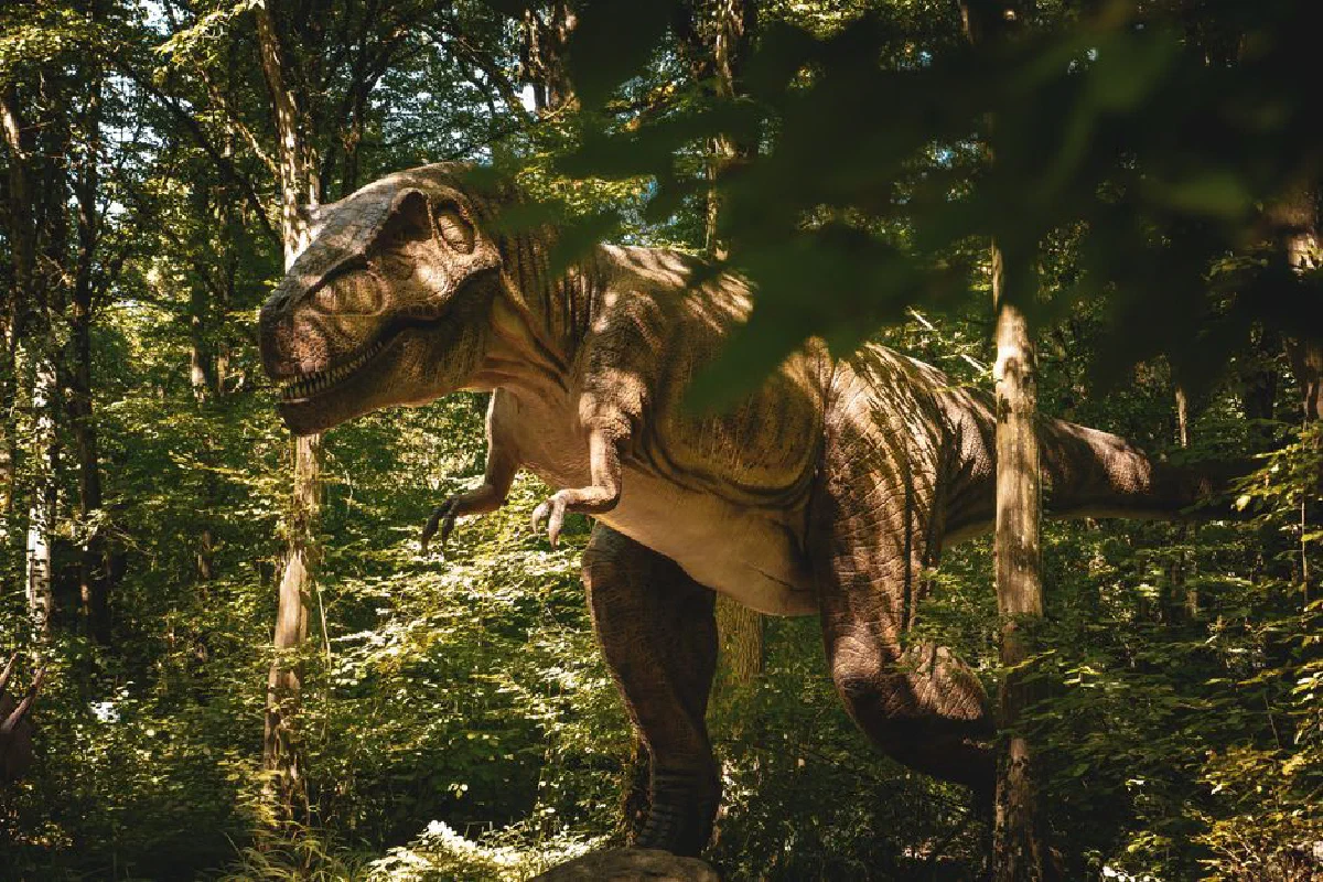 Realistic dinosaur sculpture in forest setting, capturing nature's majesty.