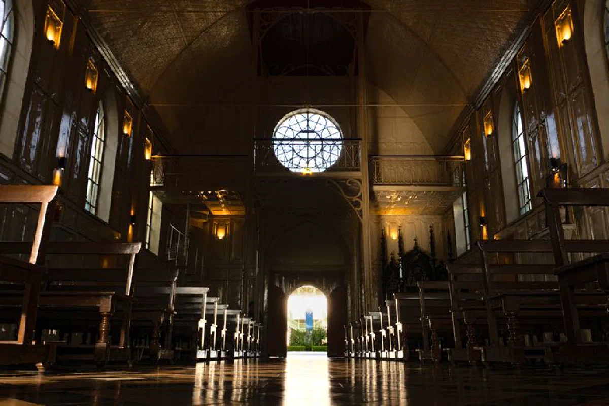 Historic church interior with sunlight and wooden benches for a serene atmosphere.