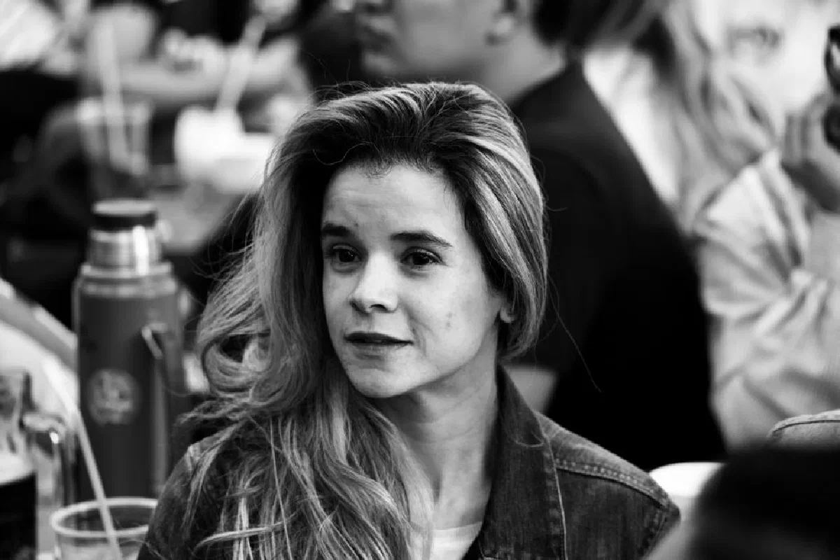 Grayscale portrait of a woman looking away in a busy setting.